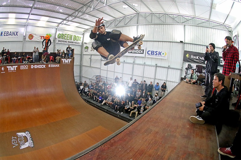 Skater high above a JBSR vert ramp in front of a crowd
